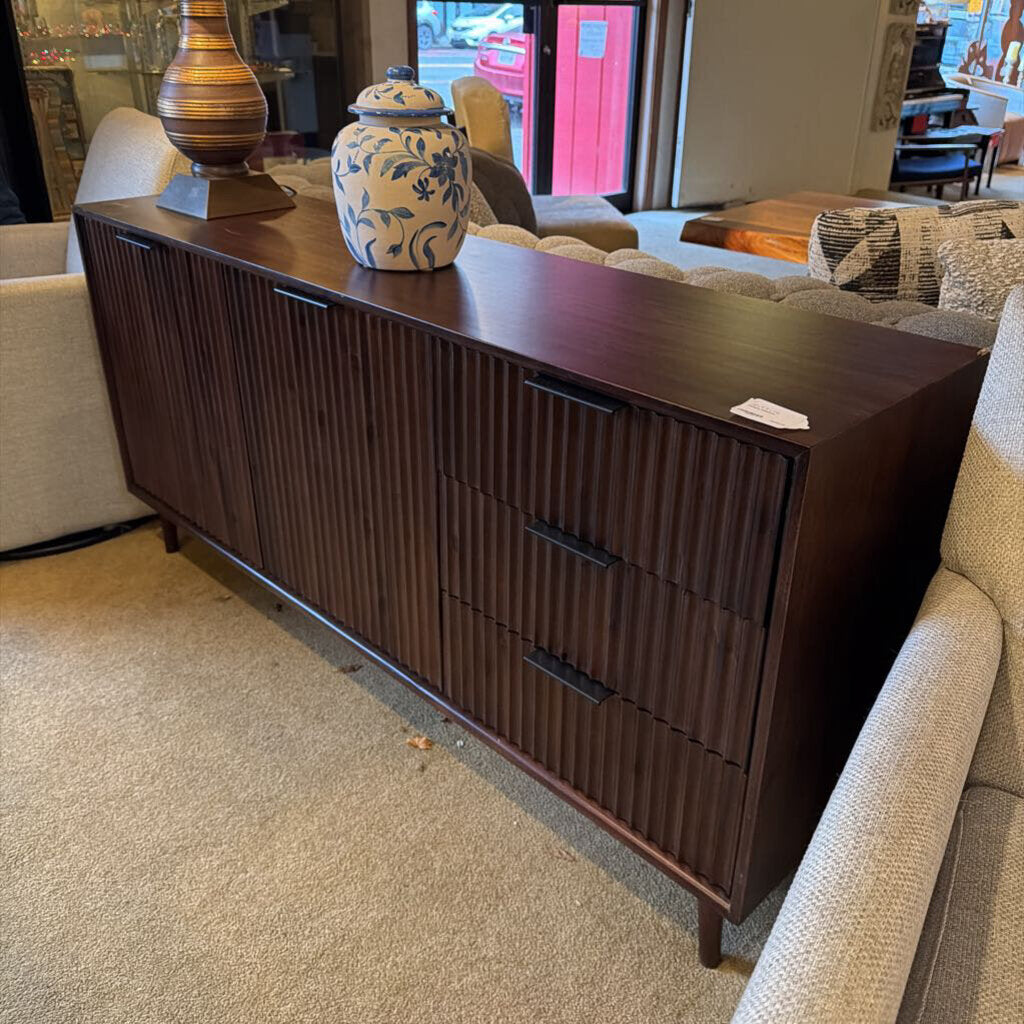 Dark wood dresser with decorative items in a living room setting