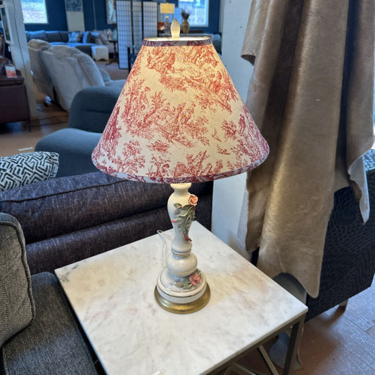 Decorative lamp with a floral pattern on a marble table in a living room.