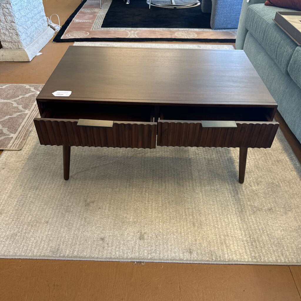 Dark wood coffee table with two drawers on a light rug