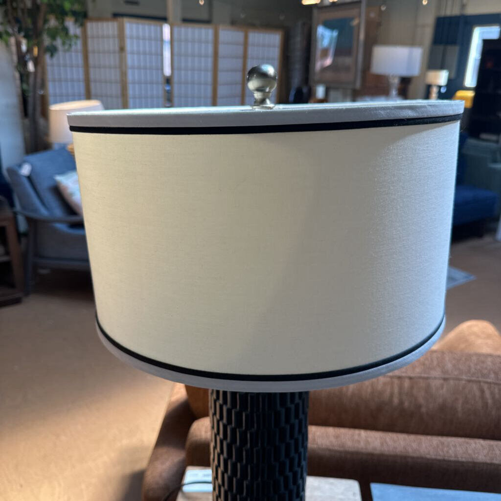 Close-up of a lamp with a beige shade in an indoor setting
