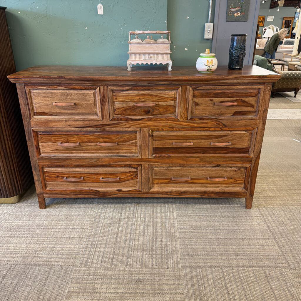 Wooden dresser with multiple drawers in a store setting