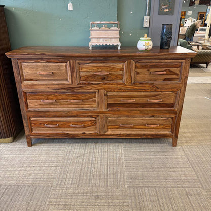 Wooden dresser with multiple drawers in a store setting