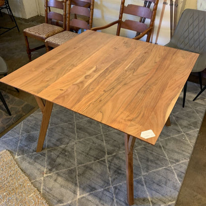 Wooden dining table with chairs in a room with tiled floor
