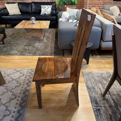 Wooden chair in a furniture store with sofas and coffee table in the background