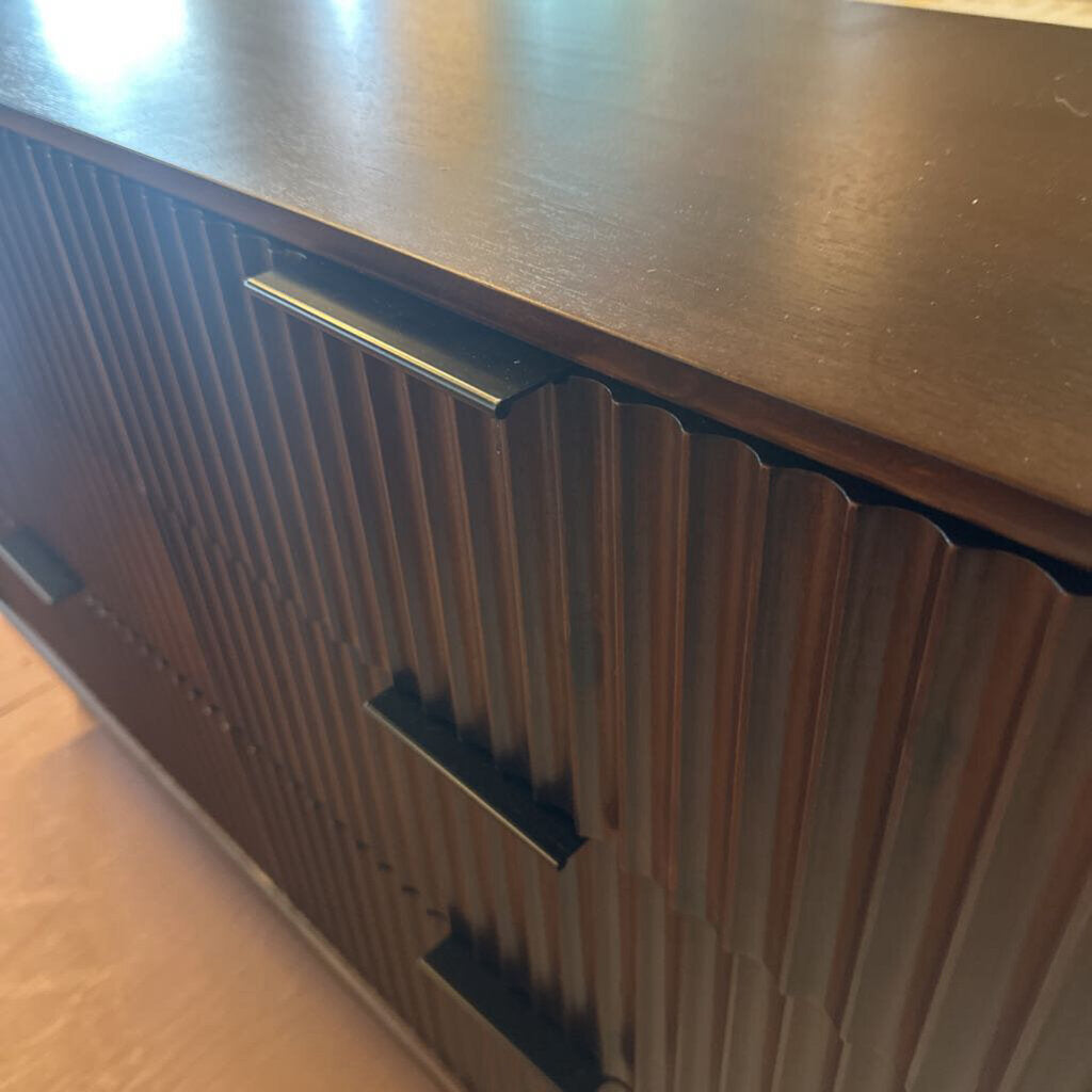 Wooden cabinet with a metallic handle on a wooden floor.