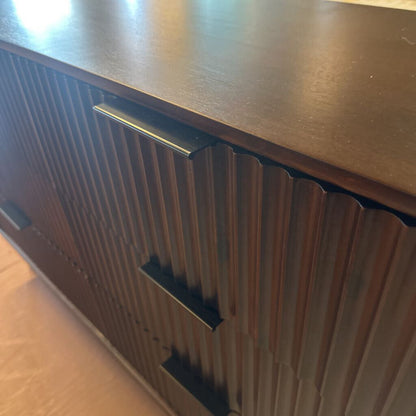 Wooden cabinet with a metallic handle on a wooden floor.