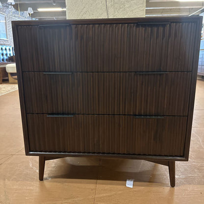Wooden dresser with three drawers on a wooden floor