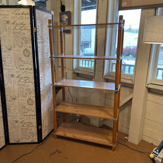 Wooden shelf in a room with a window and a decorative wall panel.