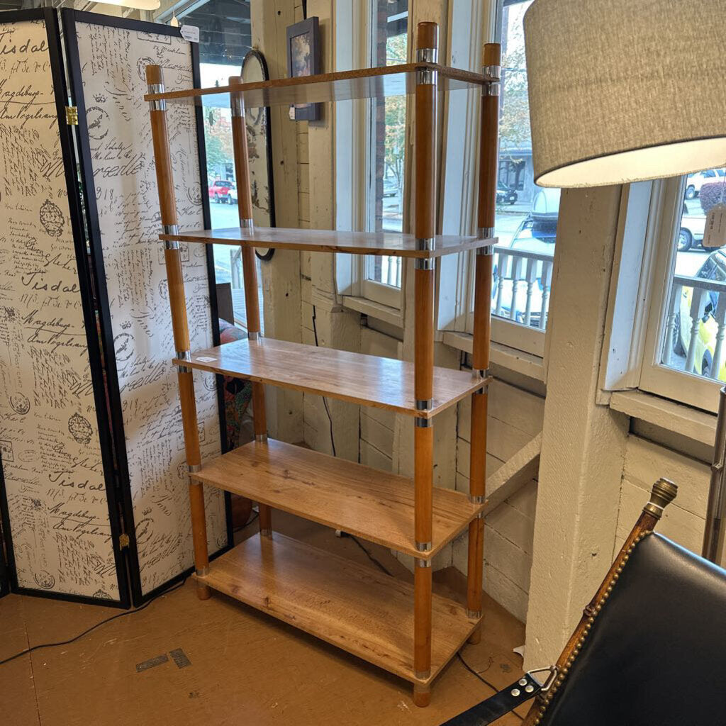 Wooden shelf with glass shelves in a room with a lamp and decorative wall.