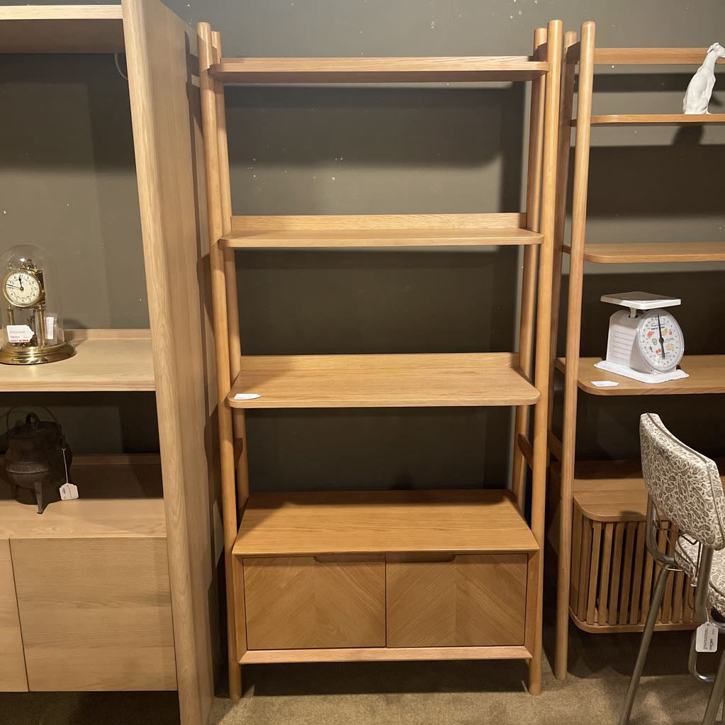 Wooden bookshelf with multiple shelves in a room setting.