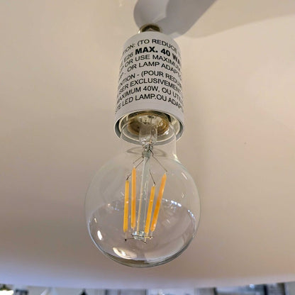 Clear LED light bulb with visible filaments against a neutral background