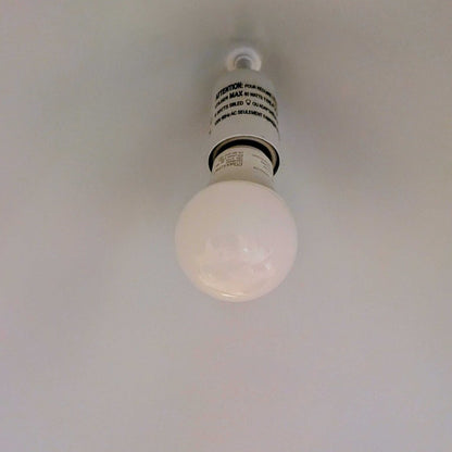 Light bulb hanging from a ceiling with a white background