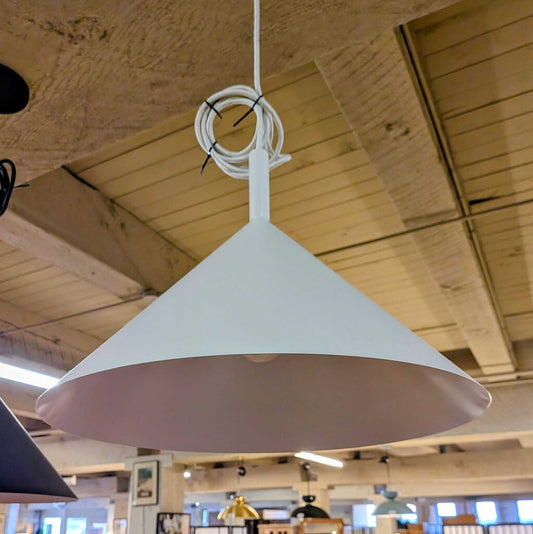 White pendant light hanging from a ceiling in a store setting