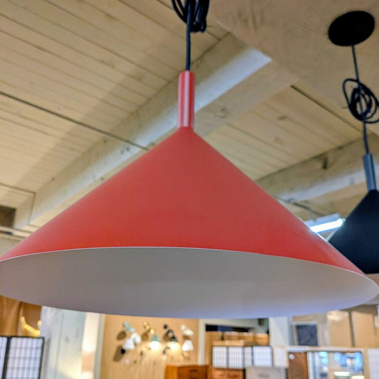 Red pendant light hanging in a room with wooden ceiling