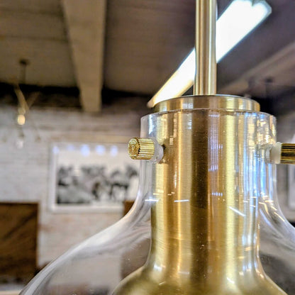 Close-up of a gold and clear glass lamp with a blurred indoor background