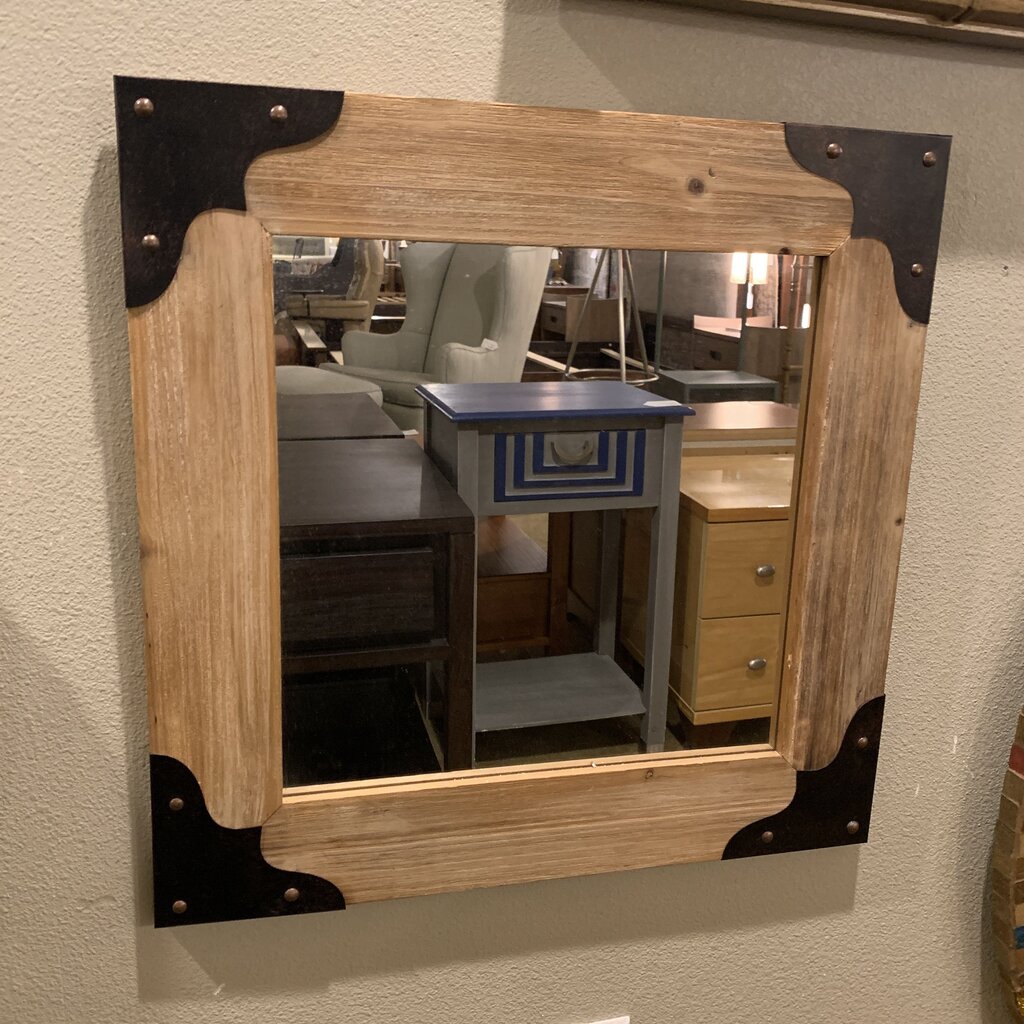 Wooden-framed mirror with metal accents on a wall
