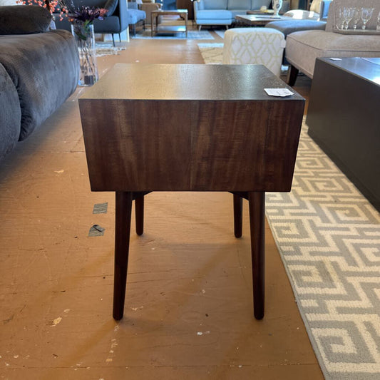Wooden side table in a living room setting with furniture and decor.