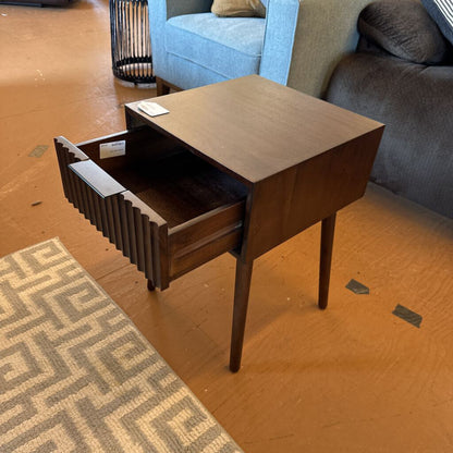 Wooden side table with a drawer in a living room setting