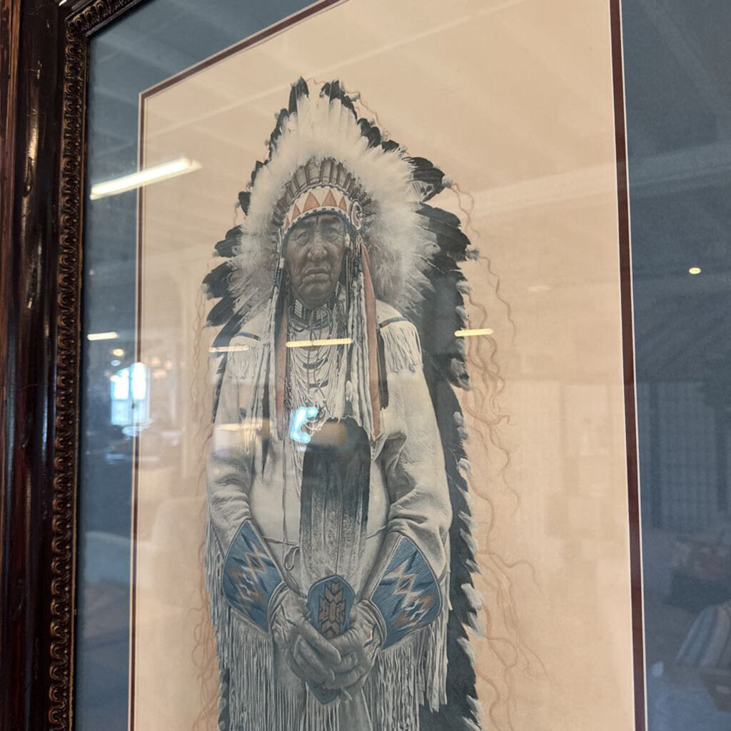 Framed artwork of a Native American figure with a headdress in a store setting.