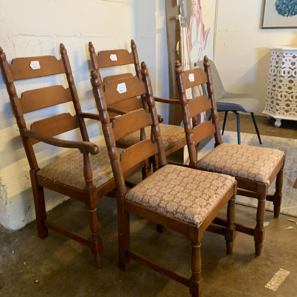 Set of wooden chairs with patterned seats in a room setting.