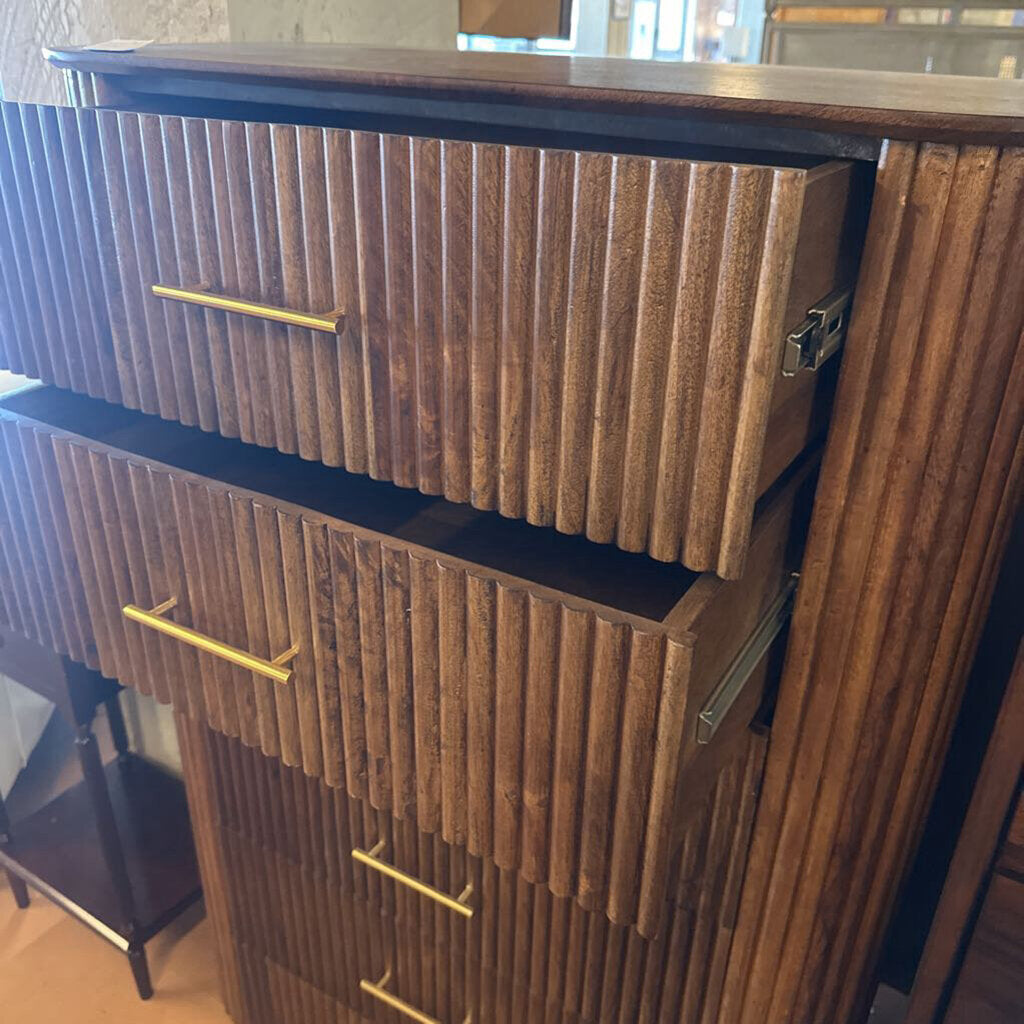 Wooden dresser with gold handles in a room setting