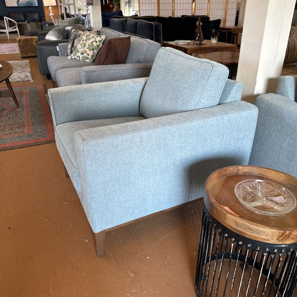 Gray armchair in a room with wooden floor and furniture