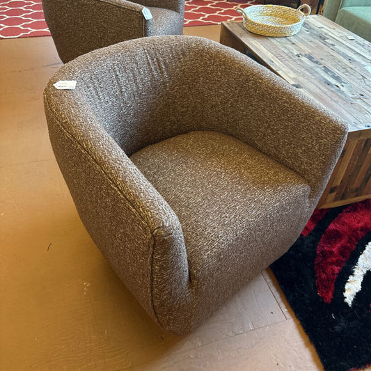 Brown textured armchair in a room with a wooden floor and rug.