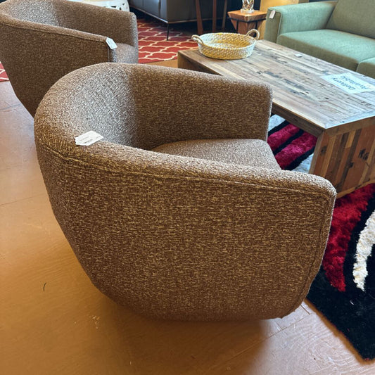 Brown textured armchair in a room with a wooden floor and furniture.