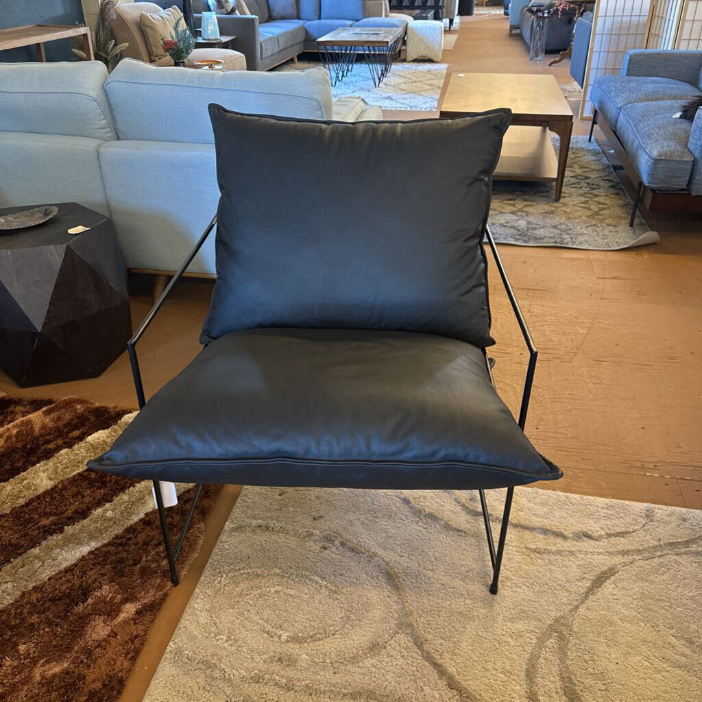 Modern chair with a large black cushion in a living room setting