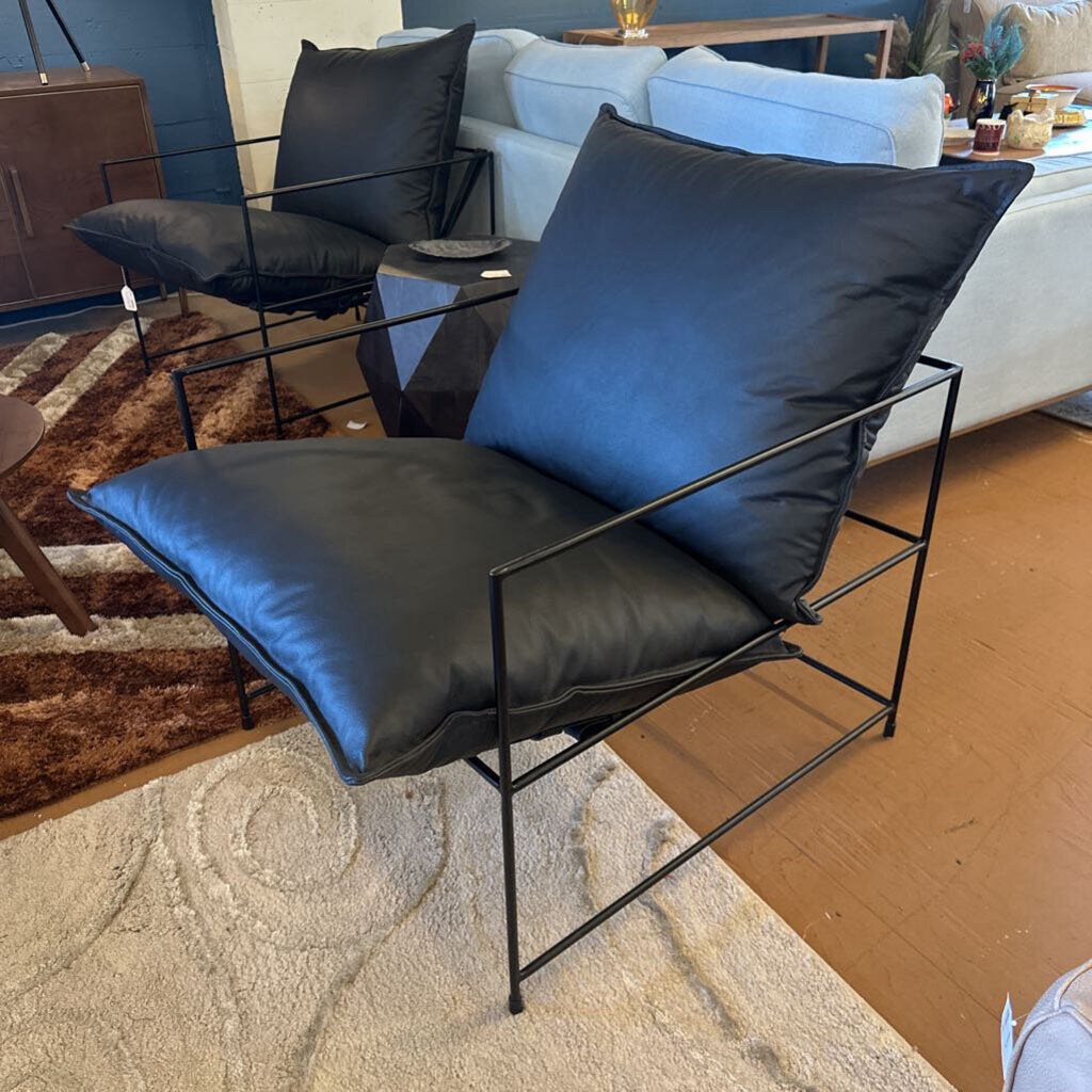 Modern black chair with blue cushions in a living room setting