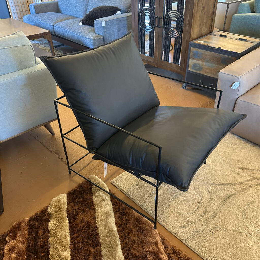 Modern black chair with cushion in a living room setting