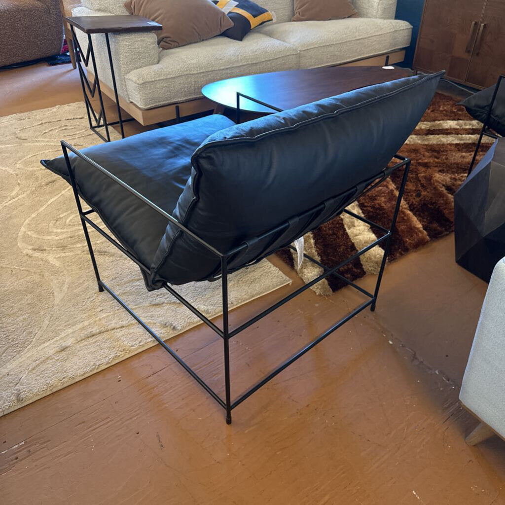 Modern black chair with blue cushion in a living room setting