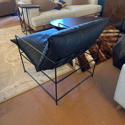 Modern black chair with blue cushion in a living room setting