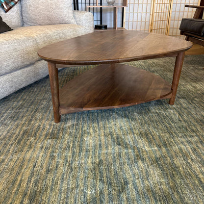 Wooden coffee table in a room with a sofa and decorative items.