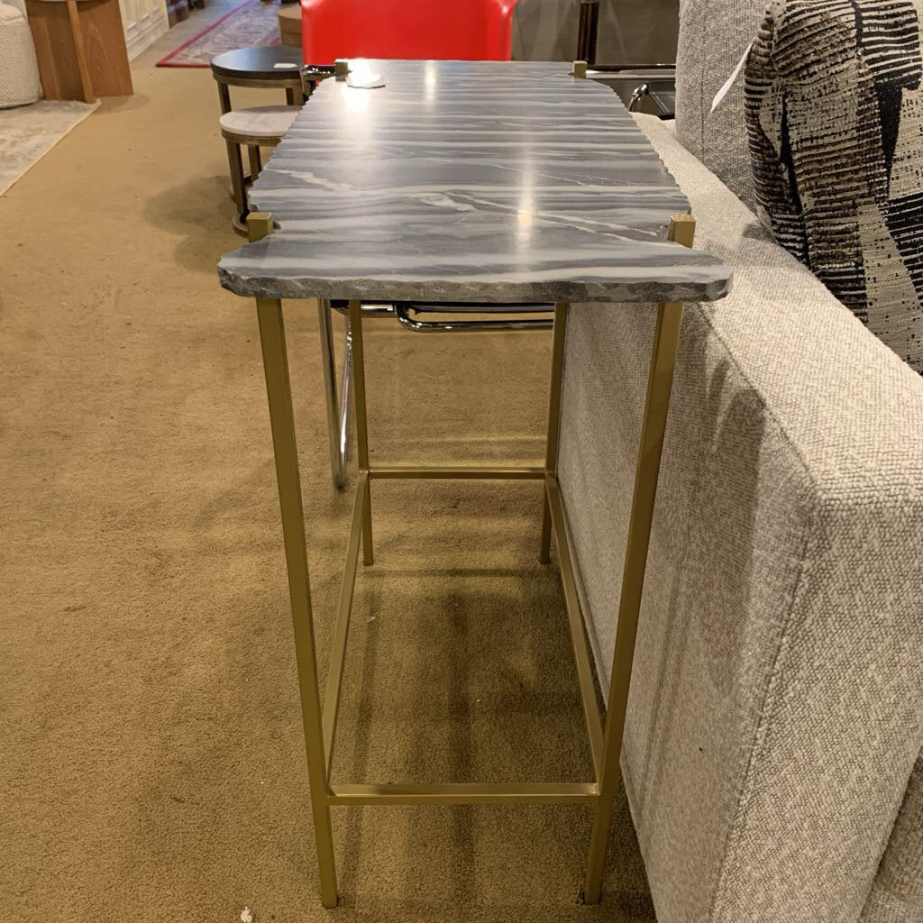 Marble-top table with gold legs in a room setting