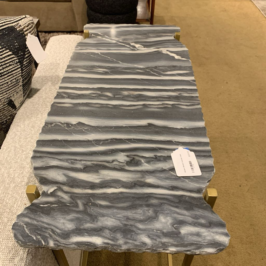 Marble-patterned slab on a stand with a price tag, on a beige surface.