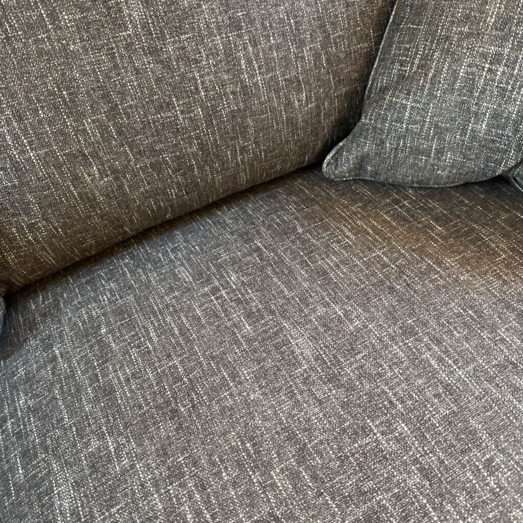 Gray textured sofa with a pillow