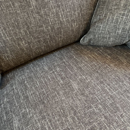 Gray textured sofa with a pillow