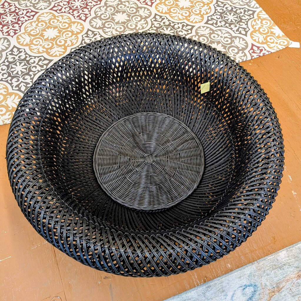Black woven basket on a patterned fabric background