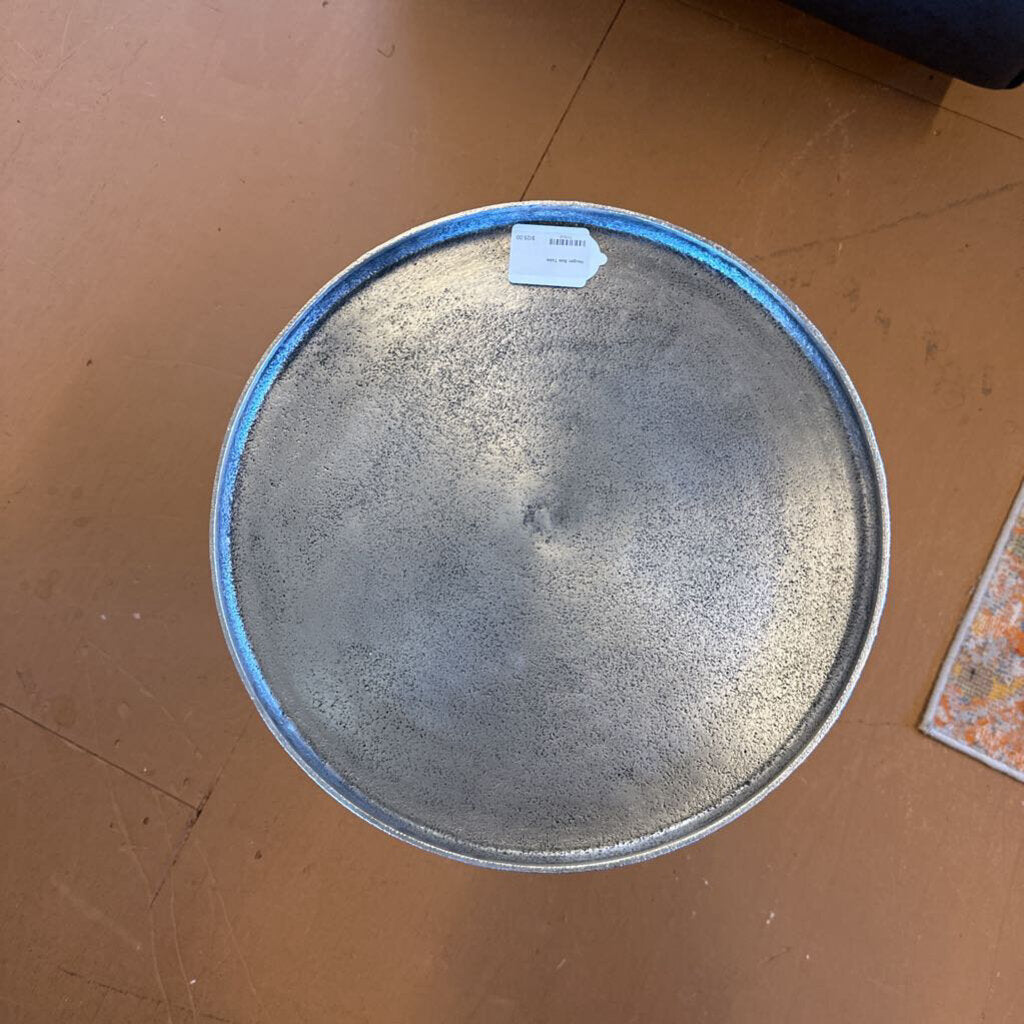 Round metal tray with blue rim on a brown surface
