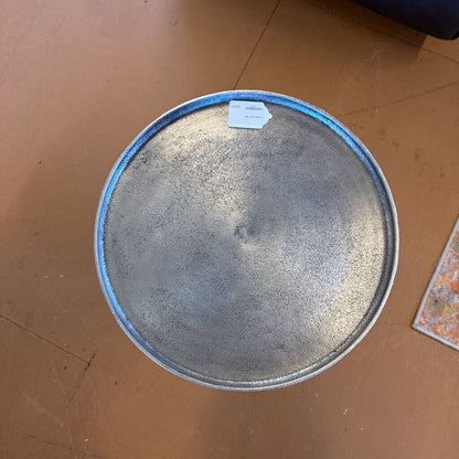 Round metal tray with blue rim on a brown surface