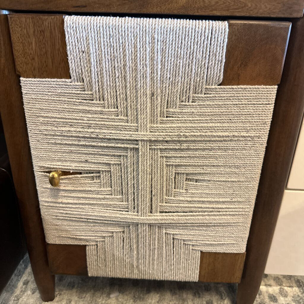 Wooden cabinet with a textured fabric panel featuring a geometric pattern.