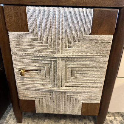 Wooden cabinet with a textured fabric panel featuring a geometric pattern.