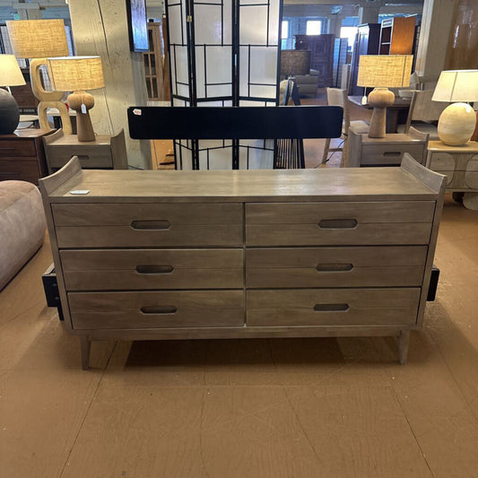 Wooden dresser with multiple drawers in a showroom setting