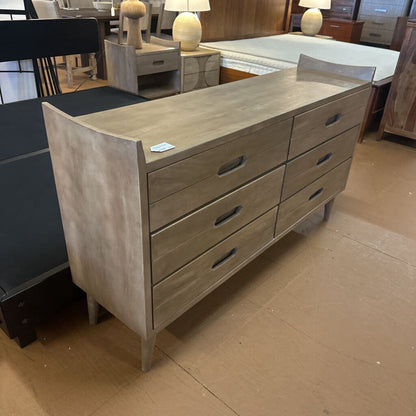 Wooden dresser with multiple drawers in a showroom setting