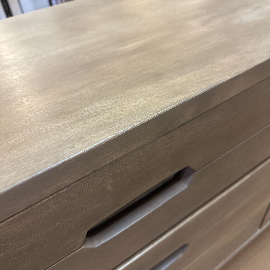 Close-up of a wooden drawer with a visible scratch.
