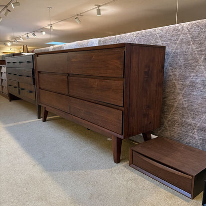 Wooden dresser with multiple drawers in a showroom setting