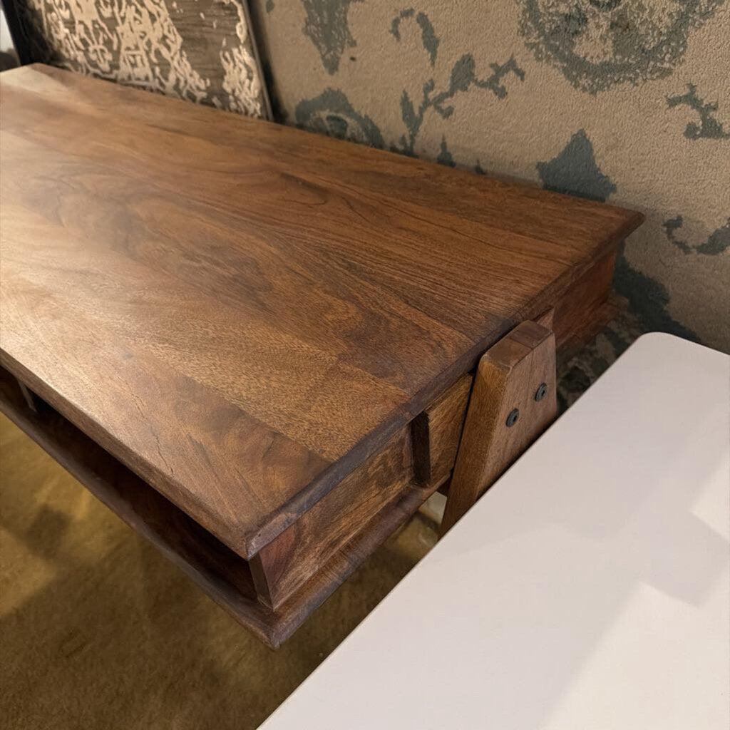 A slim, dark wood writing desk with a minimalist rectangular top, two open storage cubbies, and angled A-frame legs, shown on a neutral carpet.
