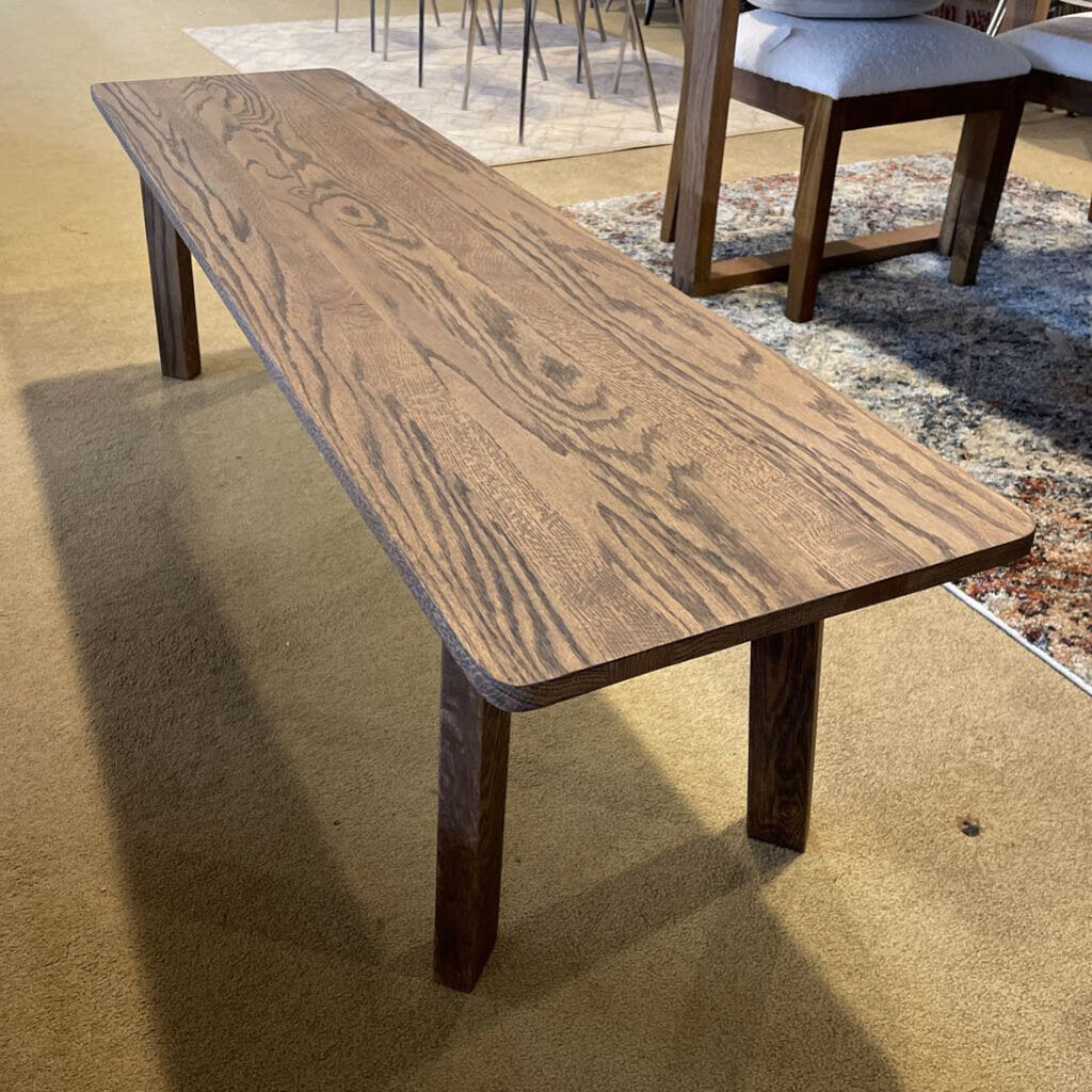 Wooden dining table in a room with chairs and a rug.