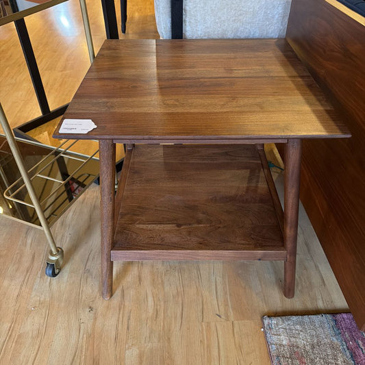 Wooden side table with a shelf on a wooden floor